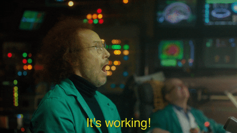 A GIF with a man cheering "it's working" in a control room.